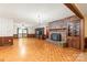 Spacious living room featuring a brick fireplace, built-in shelving, and access to the backyard deck at 3985 Well Rd, Mint Hill, NC 28227