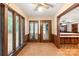 Cozy sunroom featuring wood paneling, tile flooring, large windows, and access to the kitchen, filled with natural light at 3985 Well Rd, Mint Hill, NC 28227