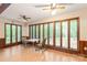Bright sunroom boasting large windows with wooded views, ceiling fan, tile floor, and seating, perfect for relaxation at 3985 Well Rd, Mint Hill, NC 28227