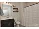 Stylish bathroom featuring a dark wood vanity, white countertop, and a shower with a textured white curtain at 402 Belton St, Charlotte, NC 28209