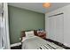 Cozy bedroom featuring a wooden bed frame, olive-green painted walls, and a built-in bookcase for bedtime stories at 402 Belton St, Charlotte, NC 28209