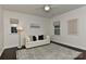 Well-lit bedroom with a modern white couch, decorative artwork, and two windows providing natural light at 402 Belton St, Charlotte, NC 28209