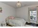 Bright bedroom featuring a plush floral patterned bed, a modern light fixture, and a sunlit window at 402 Belton St, Charlotte, NC 28209