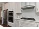 Contemporary kitchen boasts stainless appliances, white cabinetry, and stylish tile backsplash at 402 Belton St, Charlotte, NC 28209
