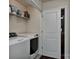 Modern laundry room with stainless steel washer and dryer, overhead shelving, and a convenient door at 402 Belton St, Charlotte, NC 28209