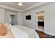 Main bedroom with closet and bathroom access features a trey ceiling, TV, and is bathed in natural light at 402 Belton St, Charlotte, NC 28209