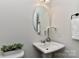 Charming powder room with pedestal sink, oval mirror, and elegant floral accents at 402 Belton St, Charlotte, NC 28209