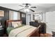 Bedroom with ceiling fan, black accent wall, hard wood floors, and traditional dresser at 407 Rosemont Ave, Kannapolis, NC 28081