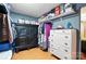 Walk-in closet with hanging clothes, storage containers, and a dark wooden storage cabinet at 407 Rosemont Ave, Kannapolis, NC 28081