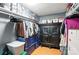 Organized closet with hanging clothes, storage bins and dark wooden cabinet for storage at 407 Rosemont Ave, Kannapolis, NC 28081