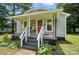 Covered porch of a gray house with chairs and gray stairs, plus well-maintained landscaping at 407 Rosemont Ave, Kannapolis, NC 28081