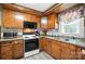 Traditional kitchen with wood cabinetry, stainless steel sink, and a stove oven combo at 407 Rosemont Ave, Kannapolis, NC 28081