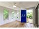 Enclosed sunroom with wood plank flooring, bright blue door, and multiple windows at 4308 Pinto Ln, Gastonia, NC 28052