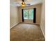 Bright bedroom featuring neutral paint, plush carpeting, a window with dark curtains, and a ceiling fan at 6184 Chandler Rd, Clover, SC 29710