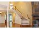 Inviting foyer with a grand staircase, slate fireplace, and elegant chandelier lighting at 6184 Chandler Rd, Clover, SC 29710