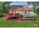 Exterior view of a home with a back deck, an outdoor living space, and a grassy yard at 6706 Farrington Ln, Charlotte, NC 28227