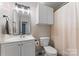 Bright bathroom featuring a vanity with sink, toilet, and a shower with curtain at 6706 Farrington Ln, Charlotte, NC 28227
