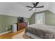 Bedroom with pitched ceiling, ceiling fan, hardwood floors, and earth-tone color palette at 6706 Farrington Ln, Charlotte, NC 28227