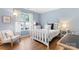 Cozy bedroom with a white bed frame, hardwood floor, and natural light at 6706 Farrington Ln, Charlotte, NC 28227