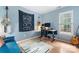 Home office with a blue accent wall, modern desk, and natural light at 6706 Farrington Ln, Charlotte, NC 28227