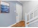 Home entryway featuring a white door, staircase, blue accent wall, and wood floors at 6706 Farrington Ln, Charlotte, NC 28227