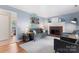 Well-lit living room features comfortable seating, fireplace and neutral-toned rug at 6706 Farrington Ln, Charlotte, NC 28227