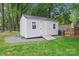 A white outdoor shed on a grassy lawn with double doors at 6706 Farrington Ln, Charlotte, NC 28227