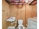 Small bathroom with wood paneling, white sink, toilet, and cabinet at 729 Montgomery Ave, Albemarle, NC 28001