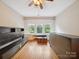 Bright bedroom with hardwood floors, ceiling fan, large windows, and built-in shelving at 729 Montgomery Ave, Albemarle, NC 28001