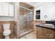 Elegant bathroom featuring a glass-enclosed shower and granite-topped vanity with storage at 7613 Happy Hollow Dr, Mint Hill, NC 28227