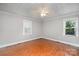 Cozy bedroom with hardwood floors, neutral walls, and two windows providing ample natural light at 7613 Happy Hollow Dr, Mint Hill, NC 28227