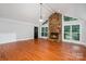 Bright living room with hardwood floors, stone fireplace, and many windows at 7613 Happy Hollow Dr, Mint Hill, NC 28227