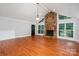 Bright living room with hardwood floors, stone fireplace, and many windows at 7613 Happy Hollow Dr, Mint Hill, NC 28227