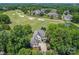 Aerial view of a home on a golf course surrounded by lush trees and green landscapes at 1032 Spyglass Ln, Waxhaw, NC 28173