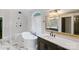 Elegant bathroom featuring a freestanding tub, marble floors, and a vanity with a framed mirror at 1032 Spyglass Ln, Waxhaw, NC 28173