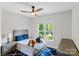 Cozy bedroom with blue accents, a plush toy, and a window showcasing the neighborhood at 1032 Spyglass Ln, Waxhaw, NC 28173