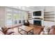 Bright living room featuring a fireplace, built-ins, French doors, and hardwood floors at 1032 Spyglass Ln, Waxhaw, NC 28173