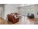 Cozy living room with hardwood floors, leather sofas, a coffee table, and access to outdoor living at 1032 Spyglass Ln, Waxhaw, NC 28173