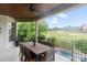 Inviting covered patio with dining table overlooking the pool, golf course, and lush greenery at 1032 Spyglass Ln, Waxhaw, NC 28173