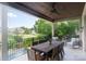 Covered outdoor space with dining table and views of the pool, golf course and landscaped backyard at 1032 Spyglass Ln, Waxhaw, NC 28173