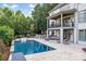 A large backyard pool features a playset and outdoor seating with a covered patio and balcony above at 1032 Spyglass Ln, Waxhaw, NC 28173