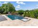 Backyard pool with in-pool seating, a basketball hoop, and professionally landscaped yard at 1032 Spyglass Ln, Waxhaw, NC 28173