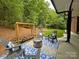 Outdoor seating area with a fire pit, wood storage, and blue patterned outdoor rug, ideal for gatherings at 11646 Hidden Forest Ln, Davidson, NC 28036