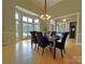 Bright dining room with hardwood floors, elegant chandelier, and a bay window at 11646 Hidden Forest Ln, Davidson, NC 28036