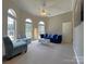 Bright living room features arched windows, plush seating, and a ceiling fan for added comfort at 11646 Hidden Forest Ln, Davidson, NC 28036