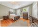Well-lit bedroom with hardwood floors, three windows, and a decorative plant at 119 Foote St, Chester, SC 29706