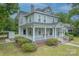 Elegant two-story home showcasing a spacious front porch, lush landscaping, and classic architectural details at 119 Foote St, Chester, SC 29706