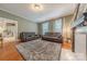 Bright living room featuring hardwood floors, a decorative fireplace, and stylish leather sofas at 119 Foote St, Chester, SC 29706