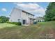 Backyard with a well-manicured lawn, mature bushes, and view of the home at 11922 Kimberfield Rd, Matthews, NC 28105