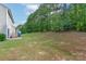 Spacious backyard with a large grassy area and mature trees at 11922 Kimberfield Rd, Matthews, NC 28105
